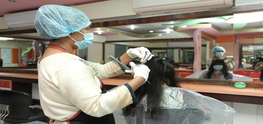 A beautician working on a customer’s hair at Nanking Beauty Center