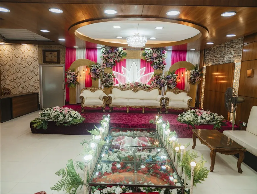 The Darbar Hall stage dressed for a wedding with flowers and a white and gold sofa